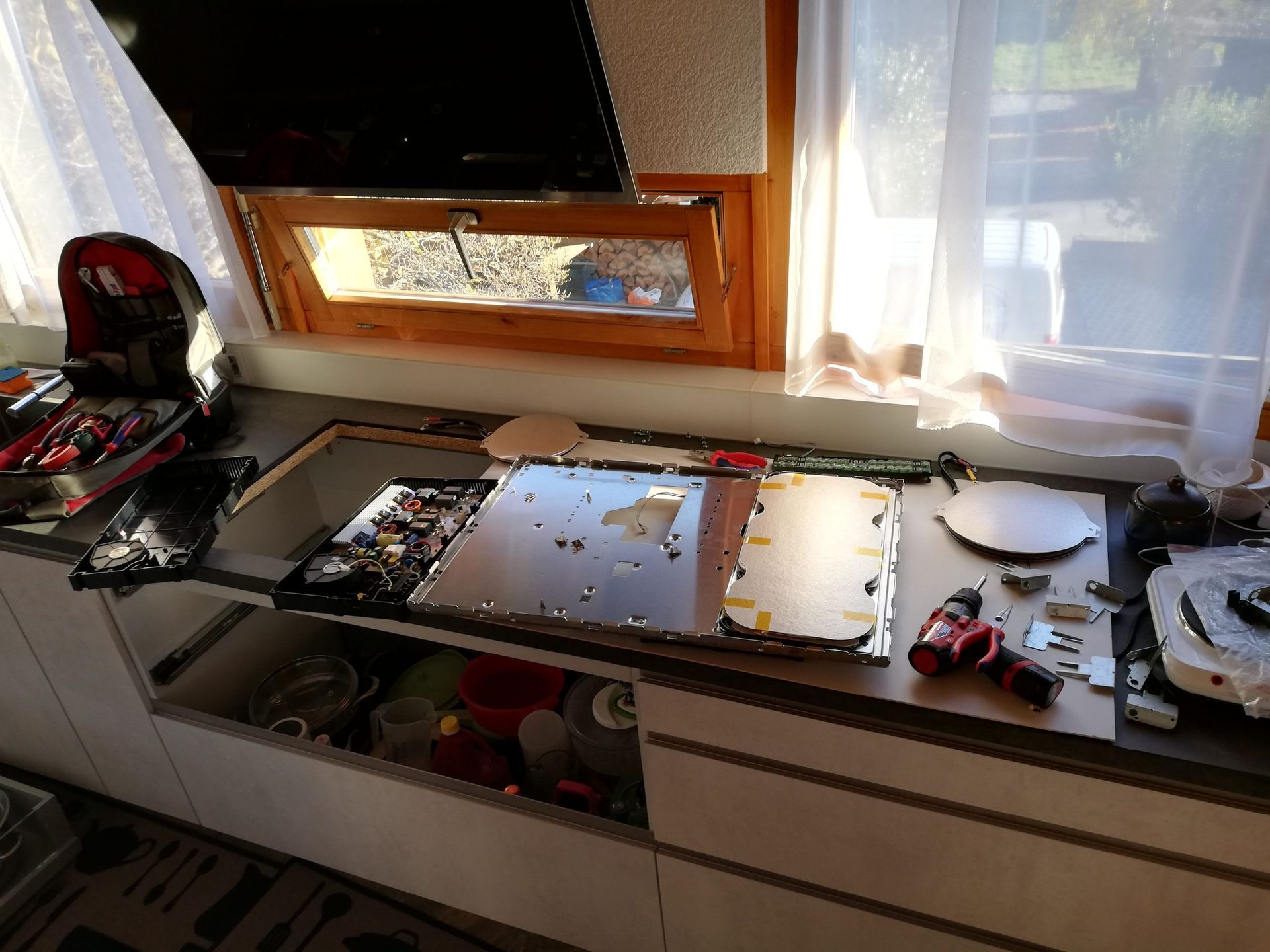 Un appareil électronique démonté sur un comptoir, avec des outils et des composants éparpillés.