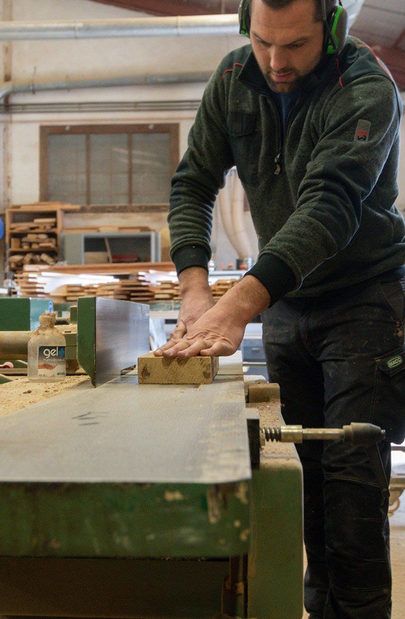 Menuisier travaillant à la découpe d'une planche de bois