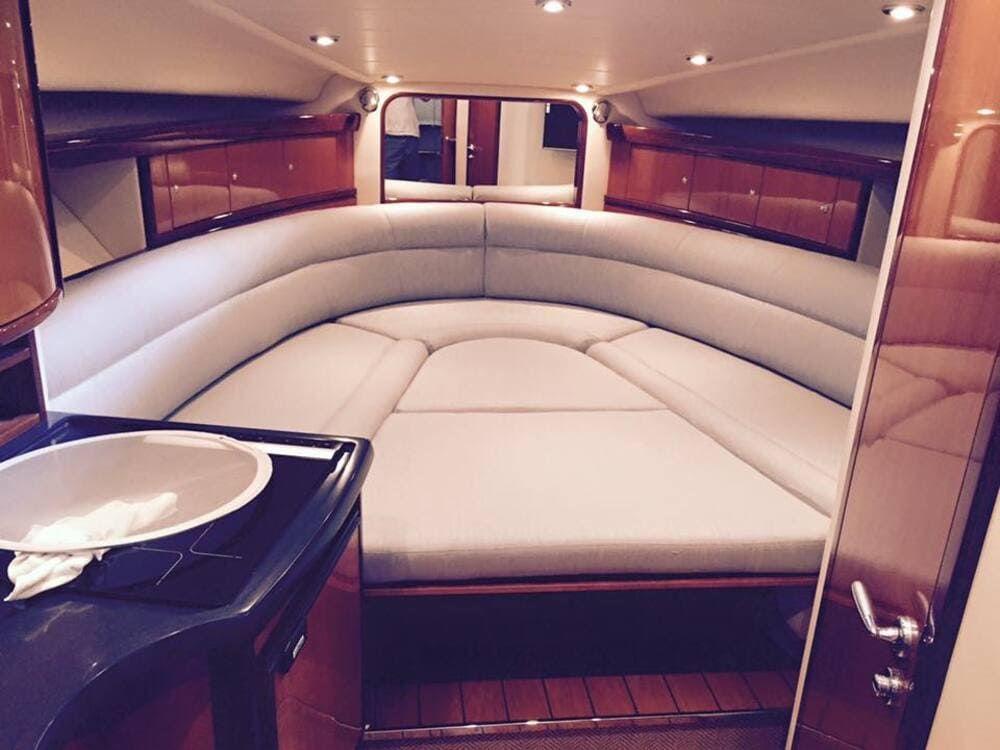 El interior de un barco con una cama y un lavabo.