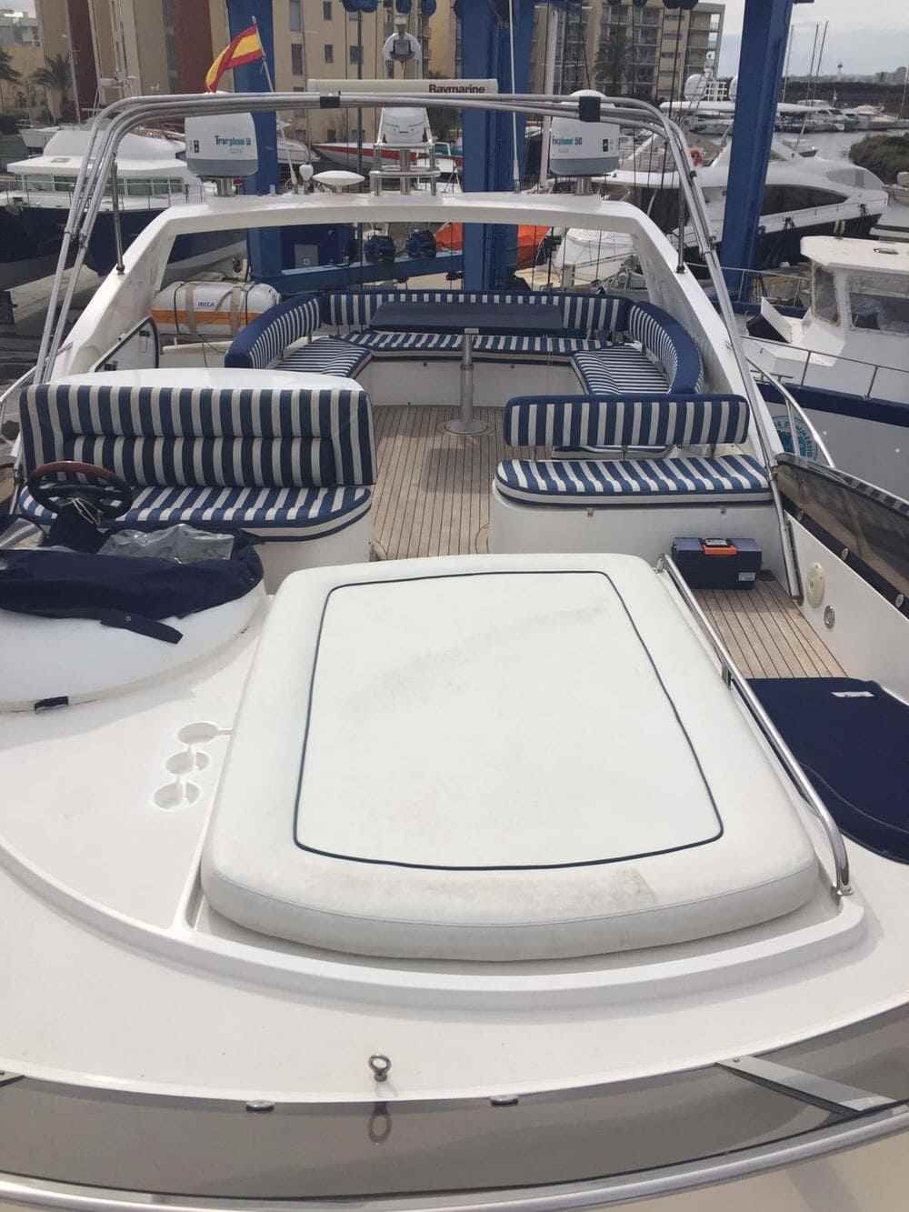 La parte trasera de un barco con un sofá y una mesa encima.