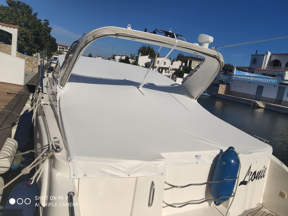 Un barco con una cubierta blanca está atracado en un puerto.