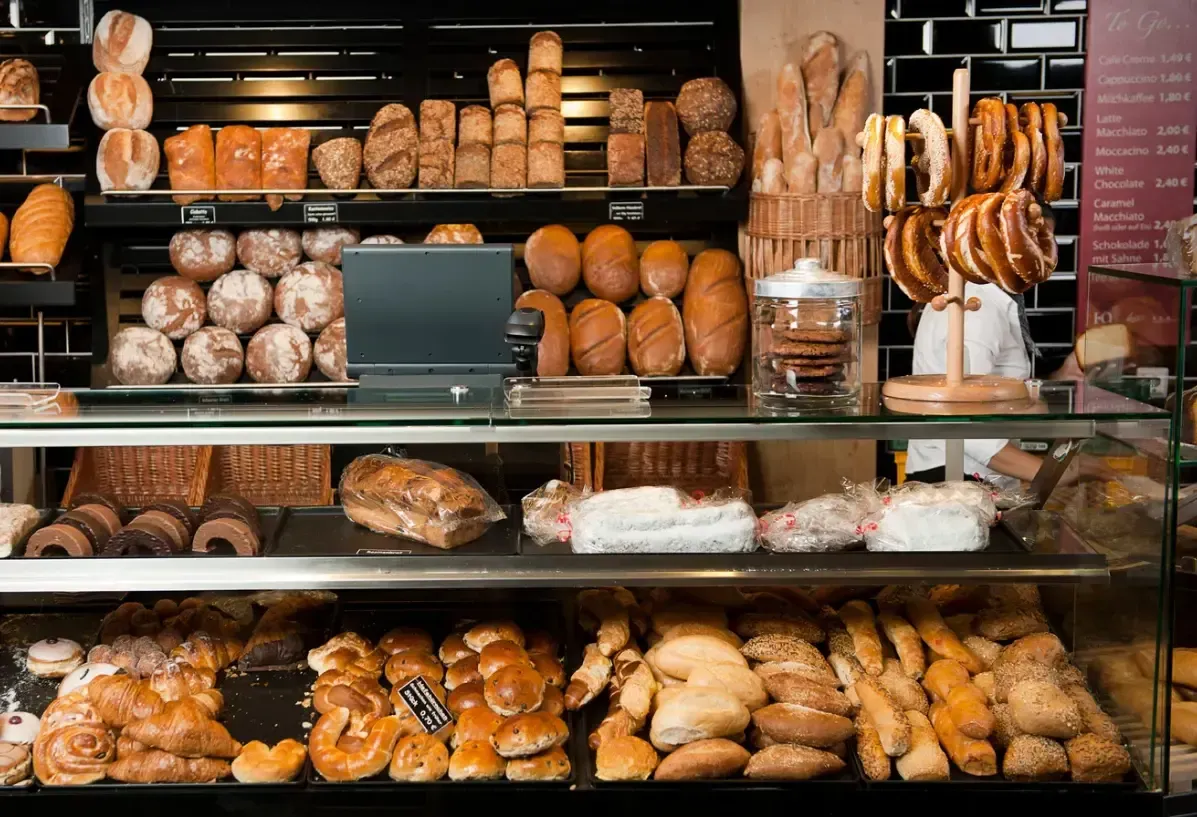 Panadería con mostrador y estanterías llenas de diferentes tipos de pan