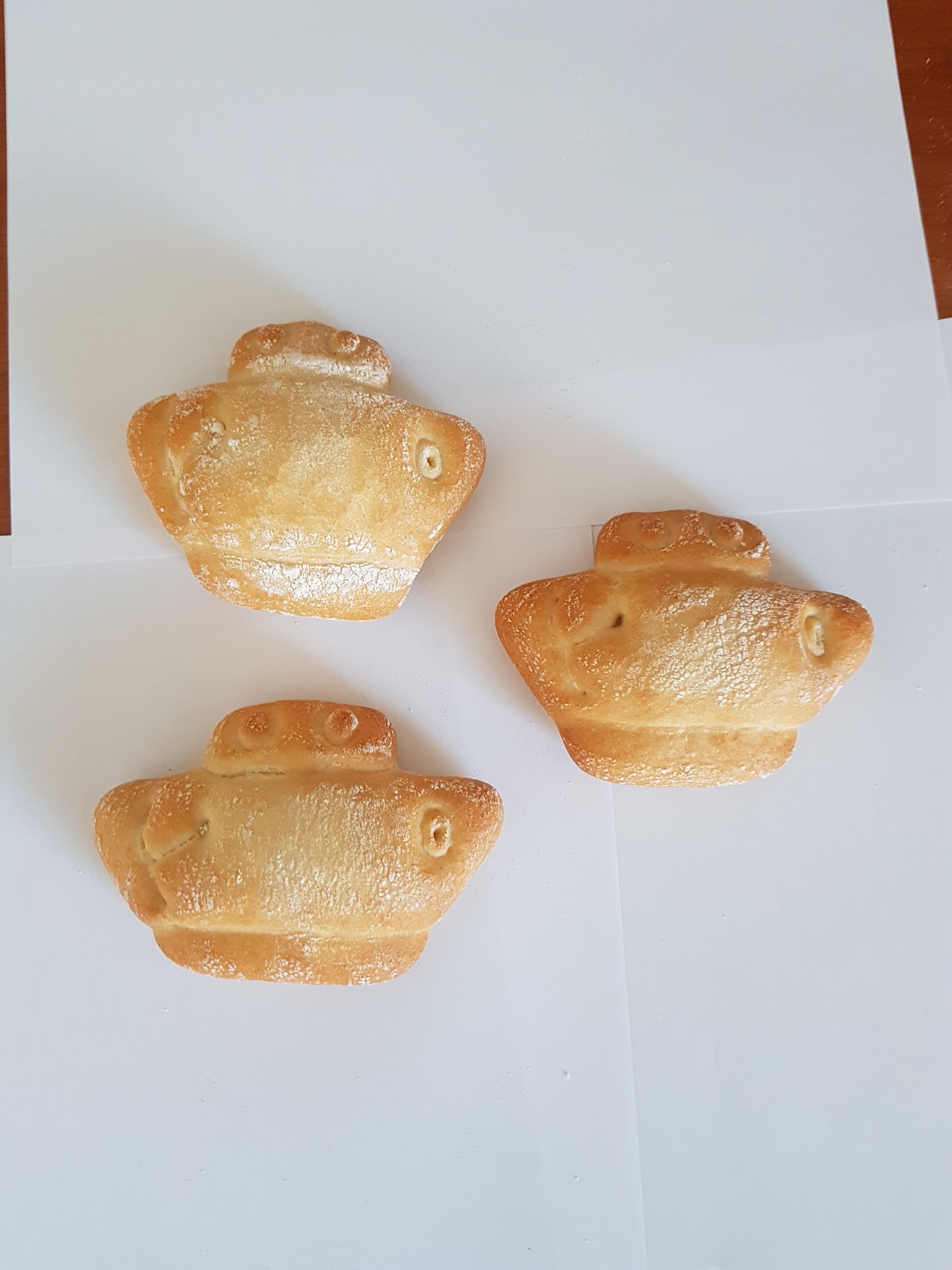 Tres pasteles con forma de pez están sobre una superficie blanca