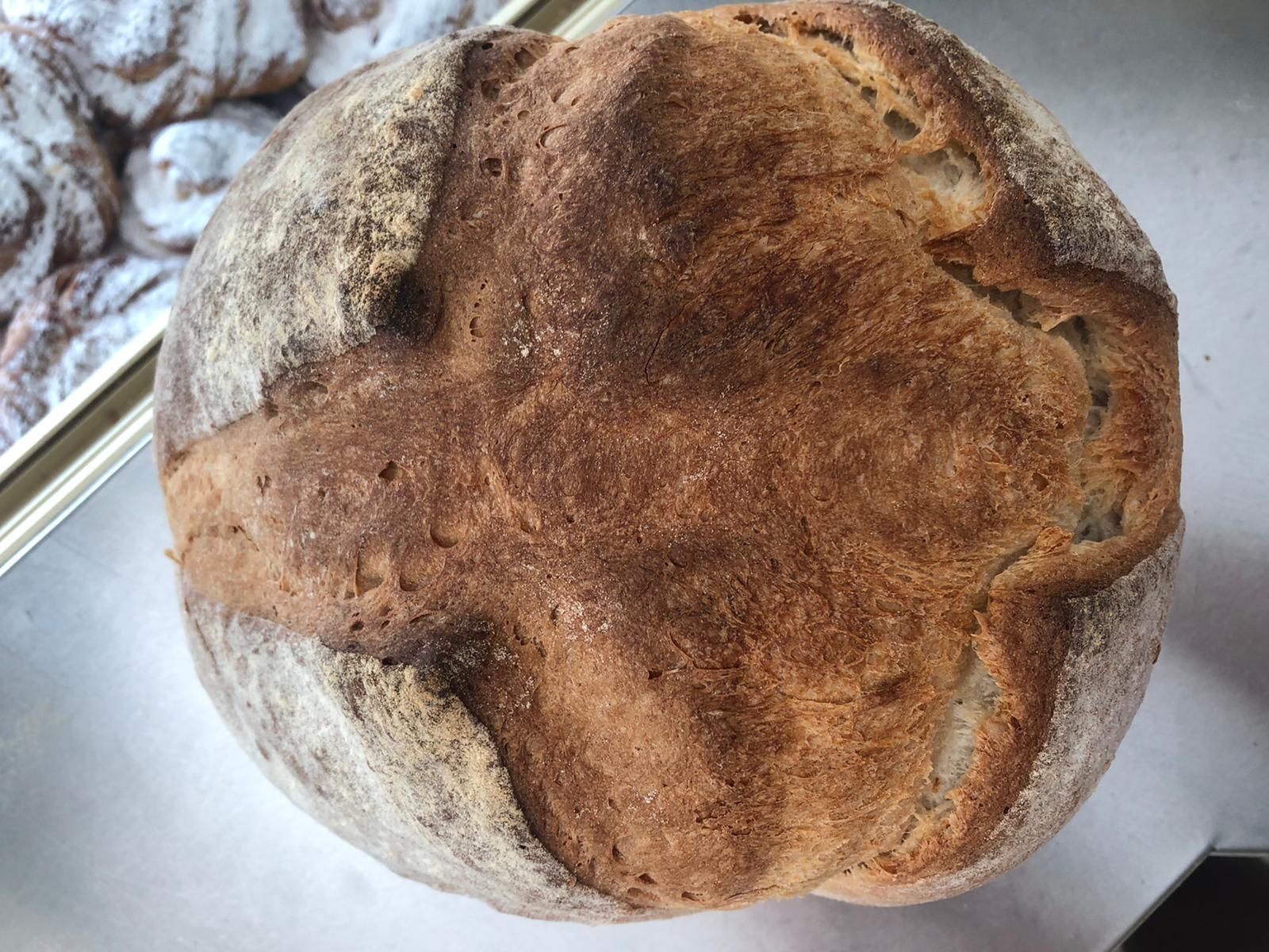 Una hogaza de pan con una cruz está sobre una mesa.