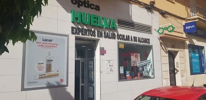 Fachada de Óptica Cartaya, una óptica, con gente paseando.