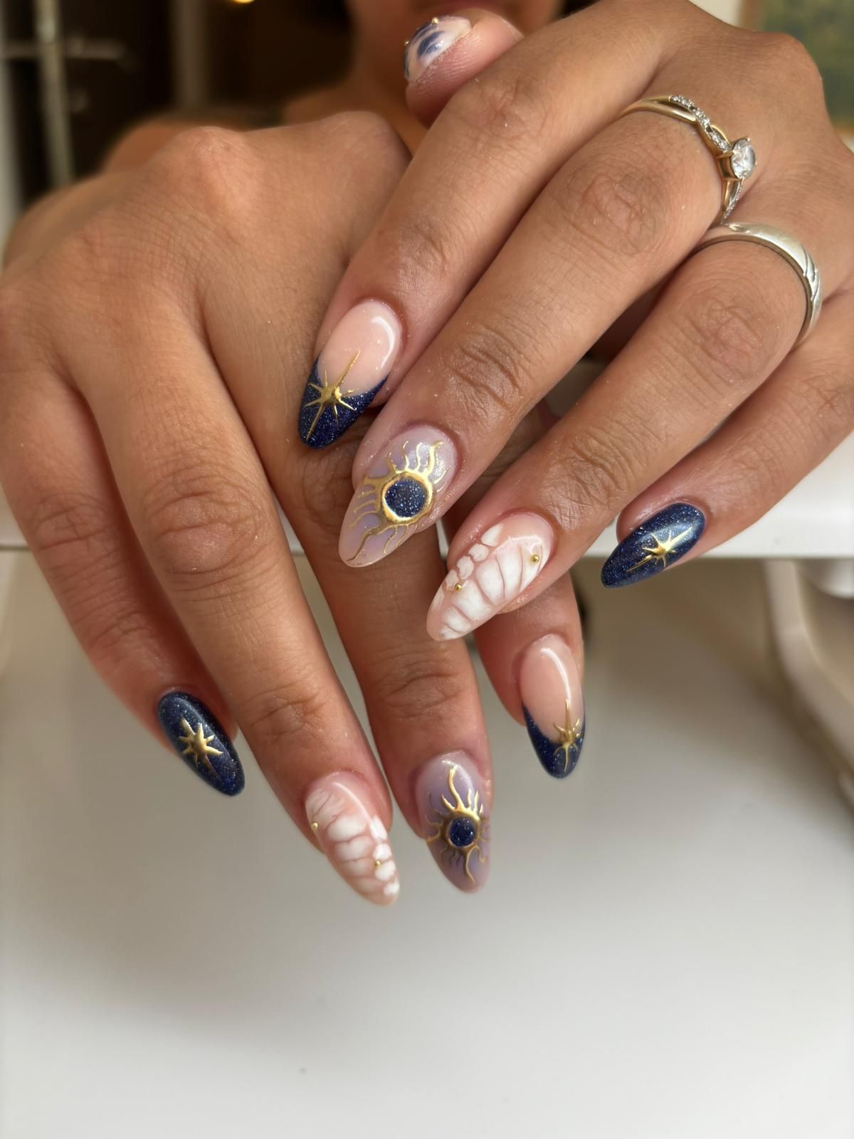 Ongles vernis avec gel, bleu pailleté et transparence, un boîtier entre les mains
