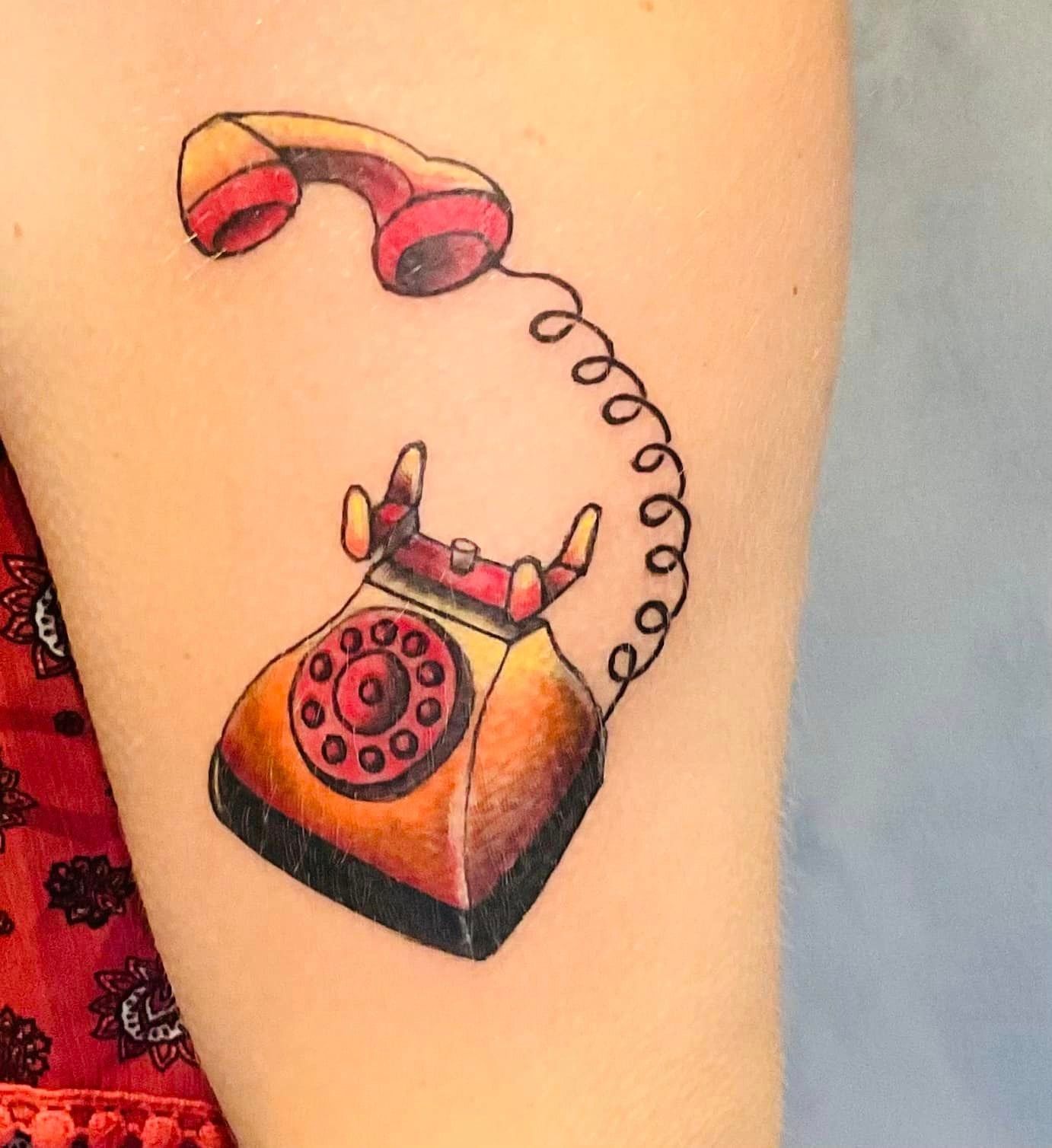 Tatouage représentant un ancien téléphone fixe rouge