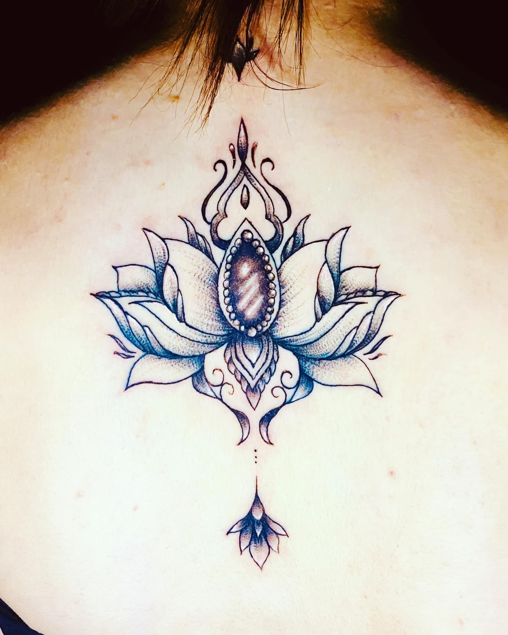 Tatouage représentant un lotus avec une pierre précieuse