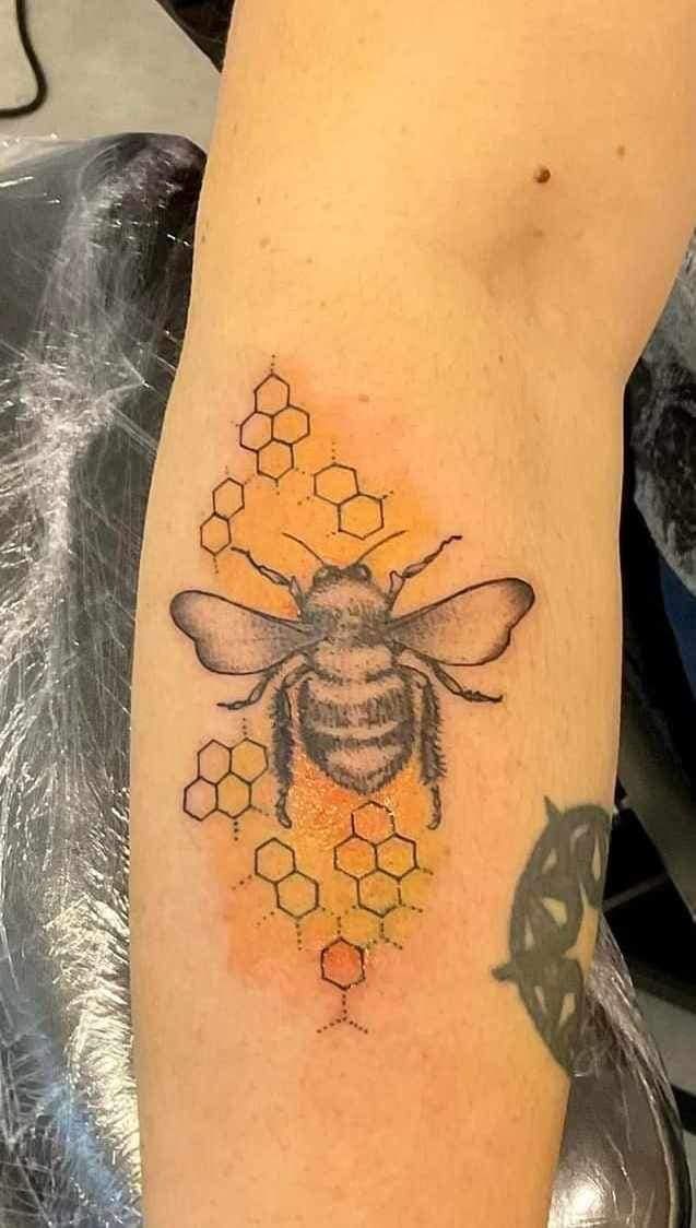 Tatouage représentant une abeille avec du miel