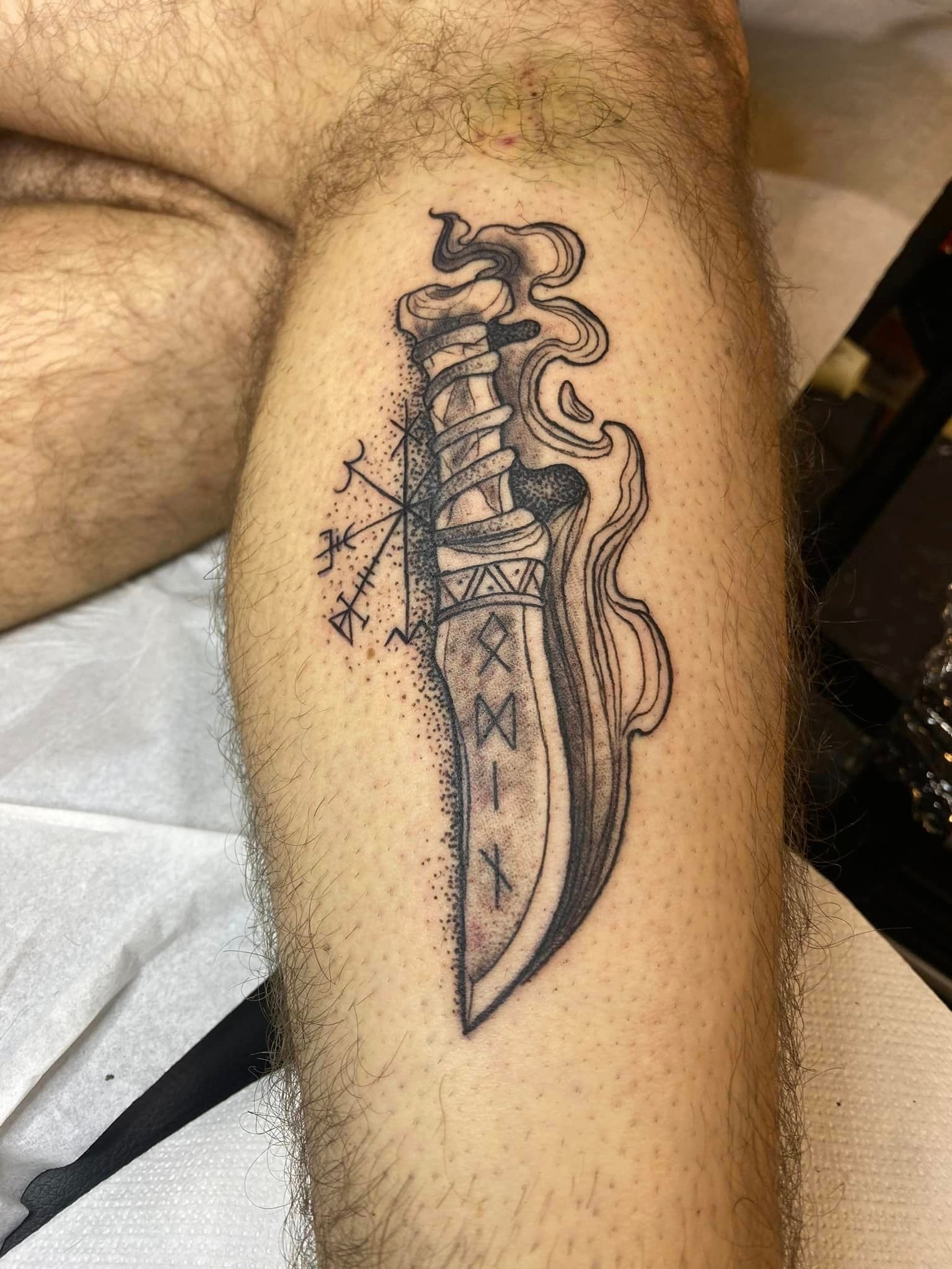 Tatouage représentant un couteau avec de la fumée