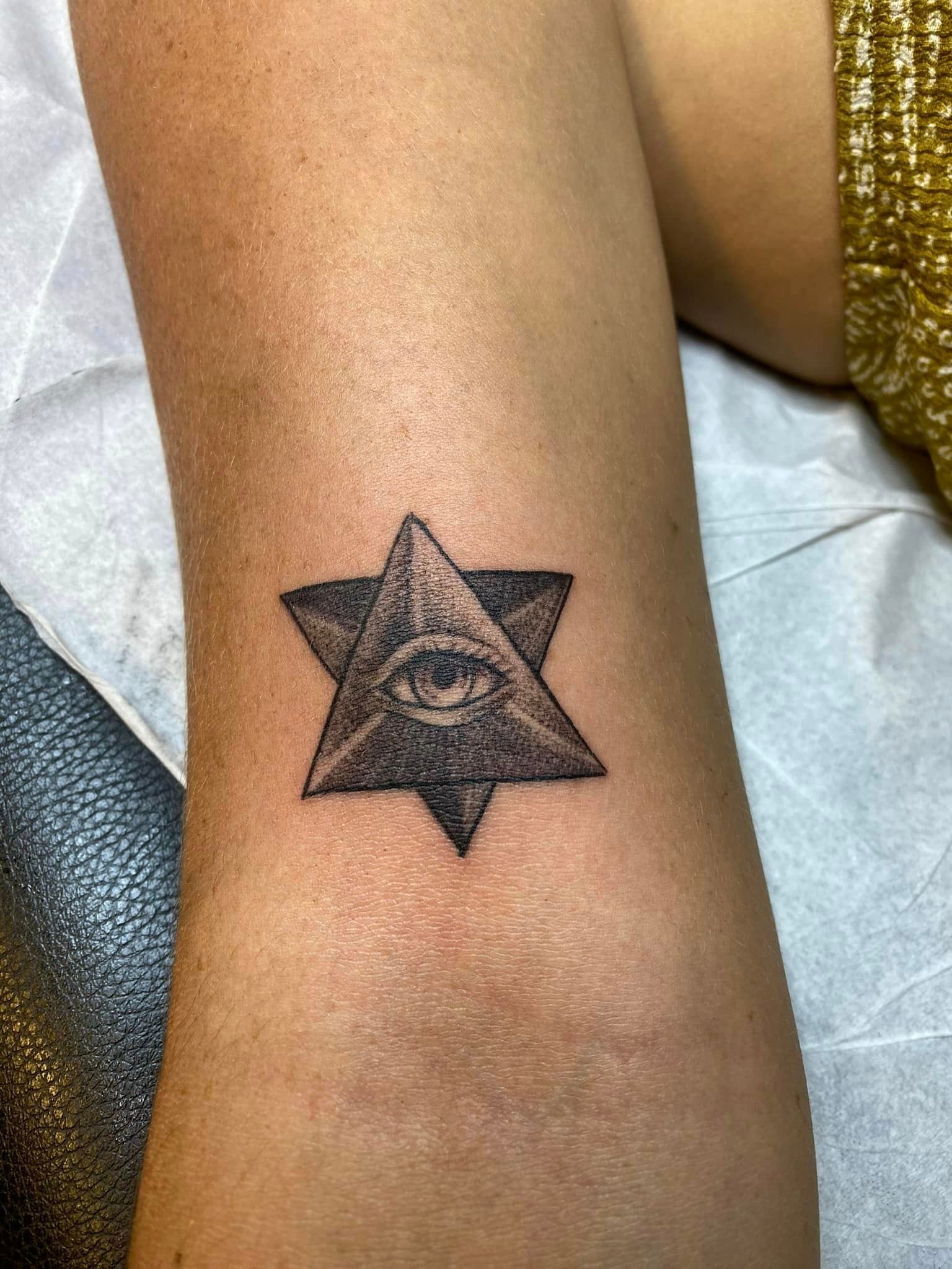 Tatouage représentant une étoile avec un œil à l'intérieur