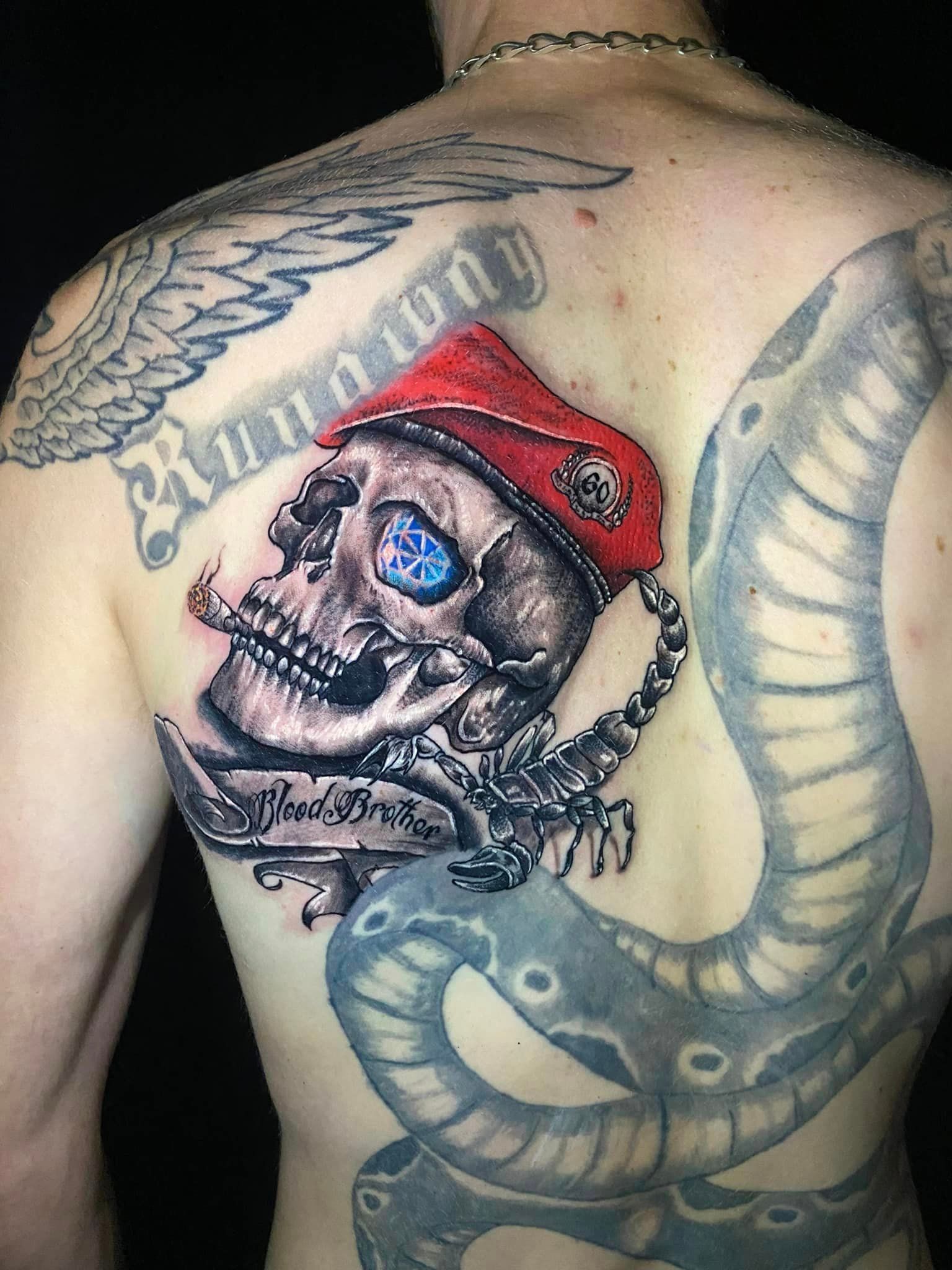 Tatouage représentant une tête de mort avec un béret militaire noir et rouge
