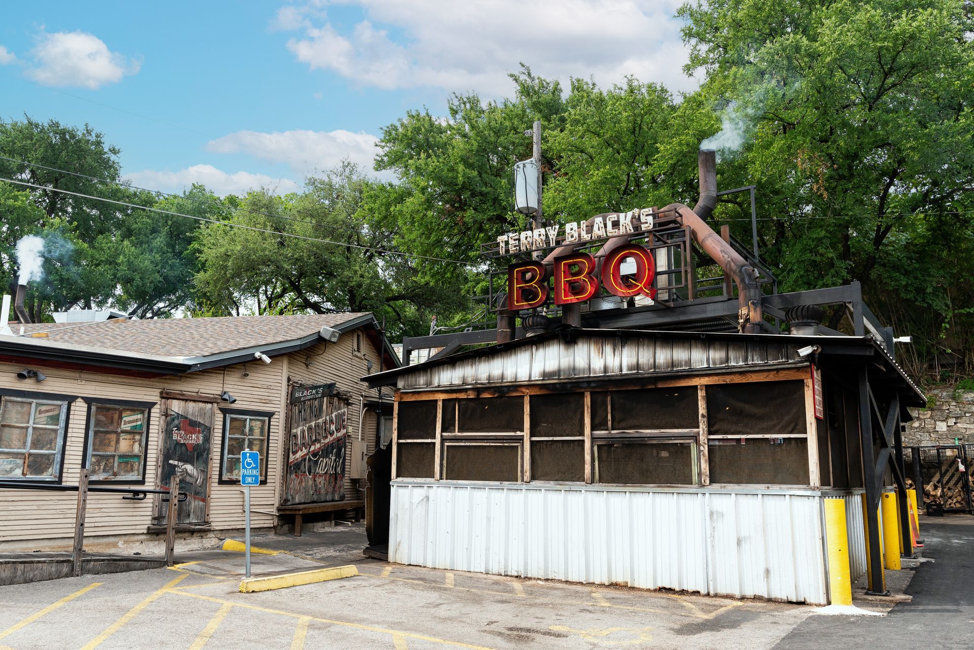 Jeffrey Black's BBQ restaurant with a weathered exterior. The red sign is above a building with a screen-enclosed area.