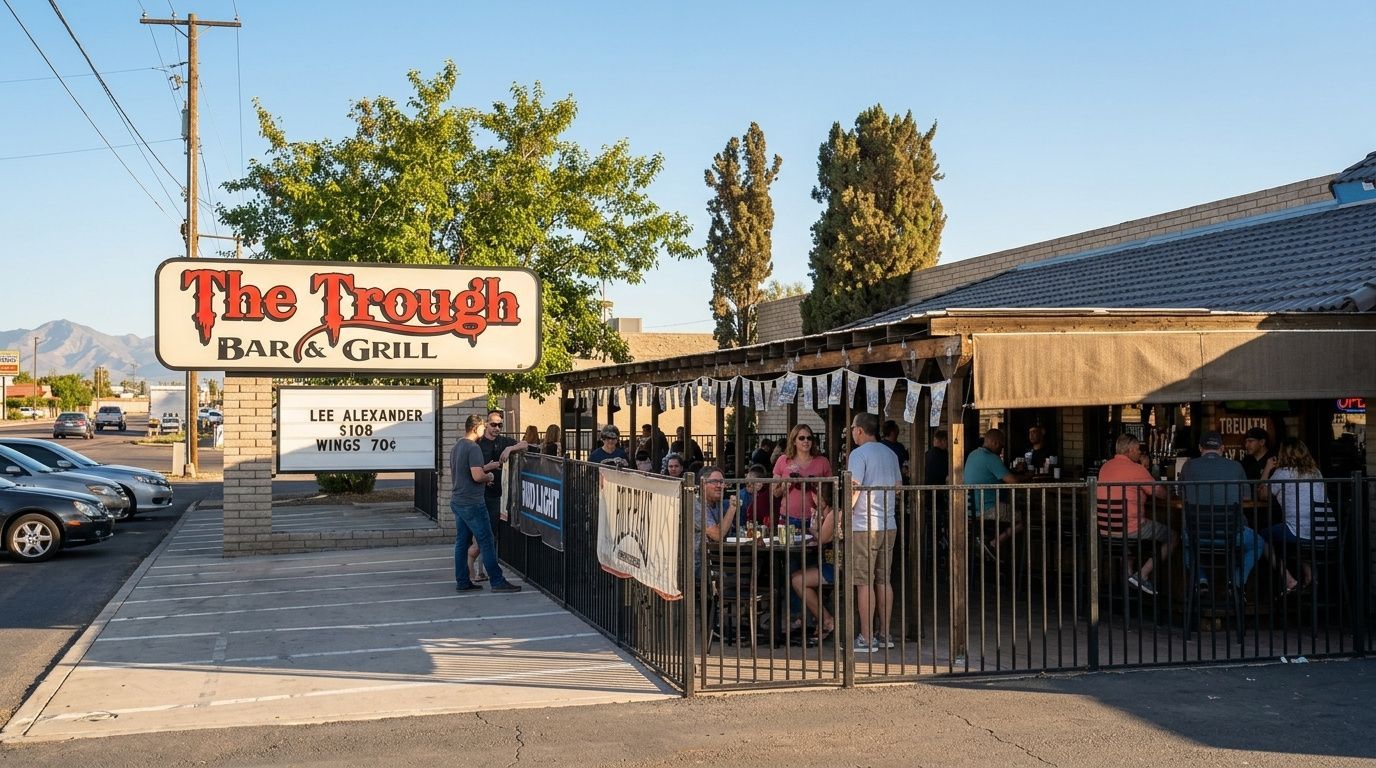 Outdoor patio of The Trough pub and bakery with diners under awnings at sunset