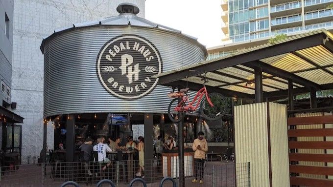 Pedal Haus Brewery, in a metal silo structure, with people gathered outdoors.