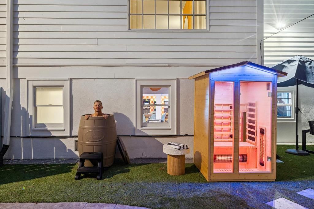 Backyard display with two illuminated portable toilets beside a house at night