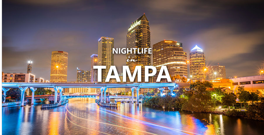 Tampa skyline at night with city lights reflecting on the water below.