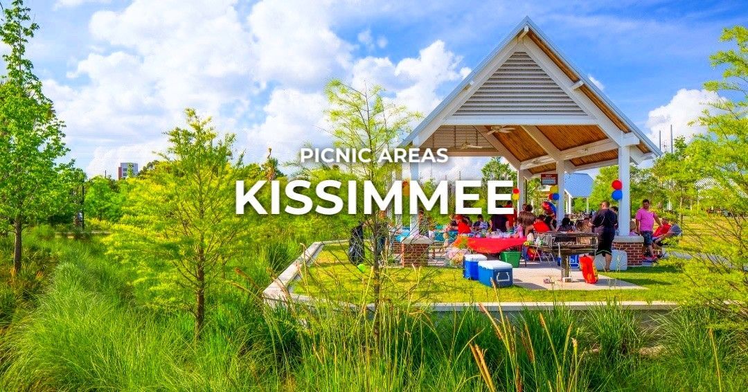 Picnic area in Kissimmee with people under a white gazebo, surrounded by green trees and grass on a sunny day.
