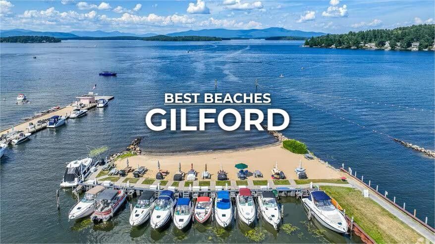 Aerial view of a beach in Gilford, with boats docked at a pier and a lake in the background.