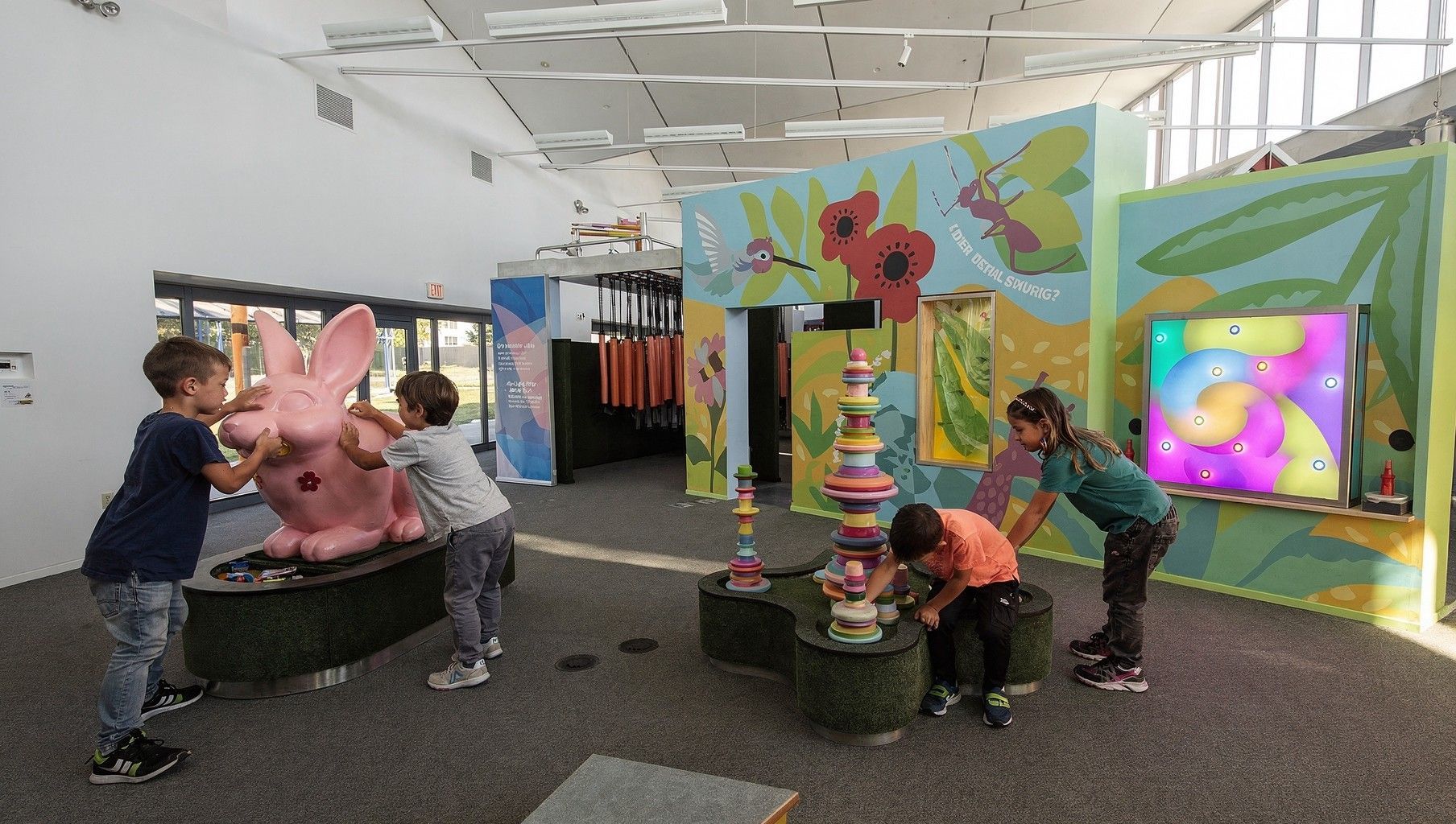 Children playing with colorful interactive displays in a bright indoor play area