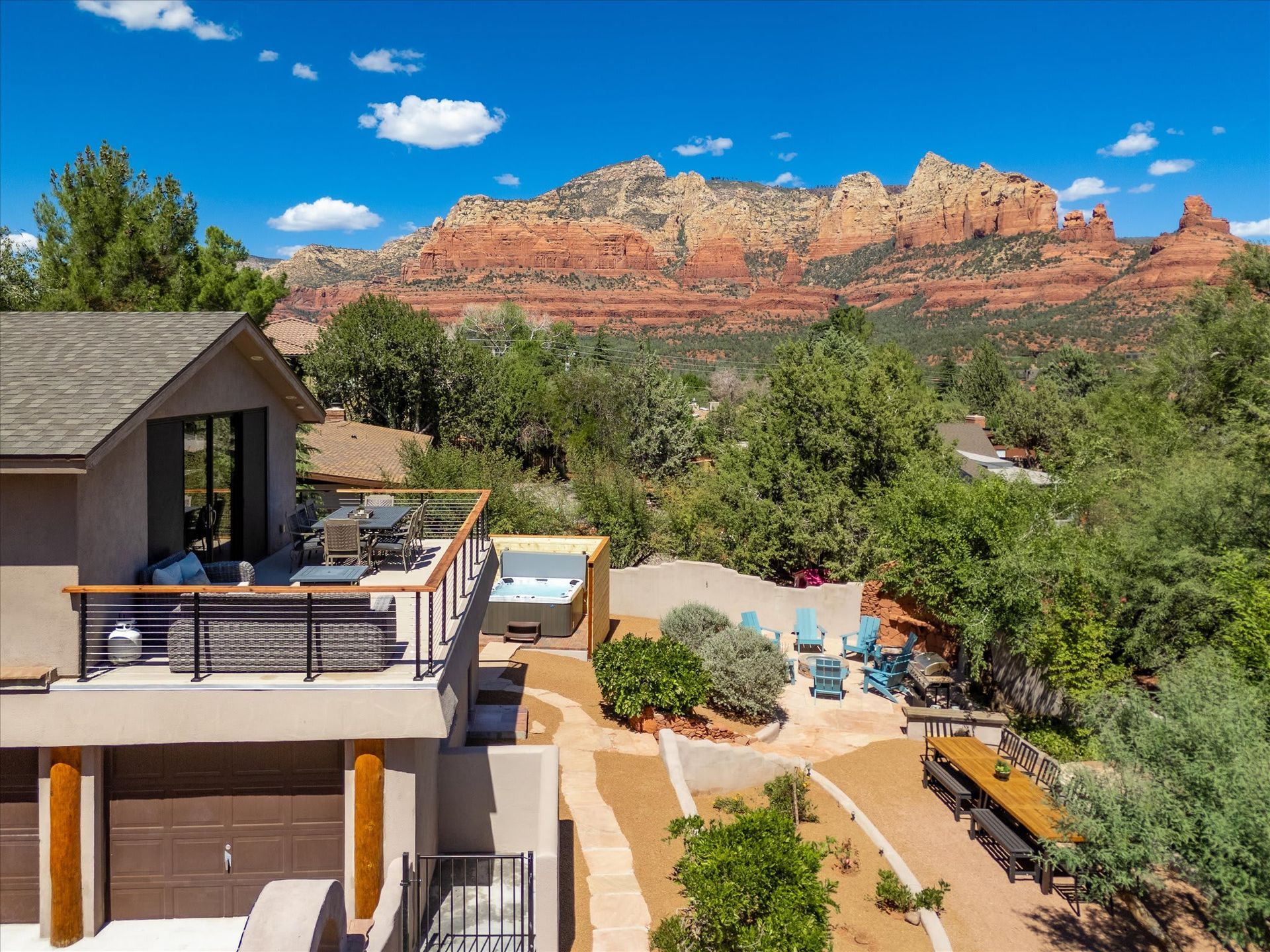 Desert home patio with pool, trees, and red sandstone cliffs under a blue sky