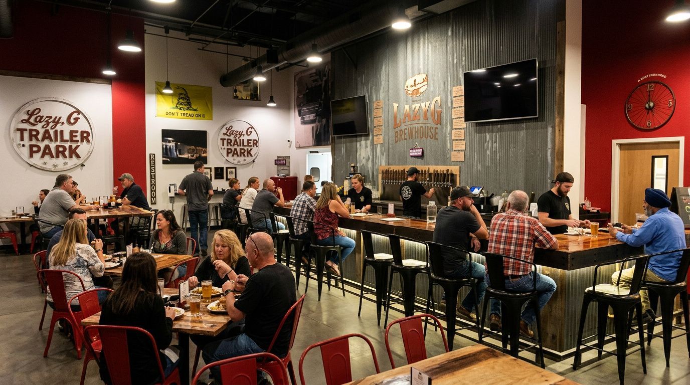 Bustling brewery taproom with people seated at tables, warm lighting, and a wall-mounted TV