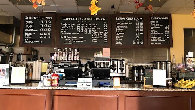 Coffee shop counter with menus, equipment, and autumn decorations.