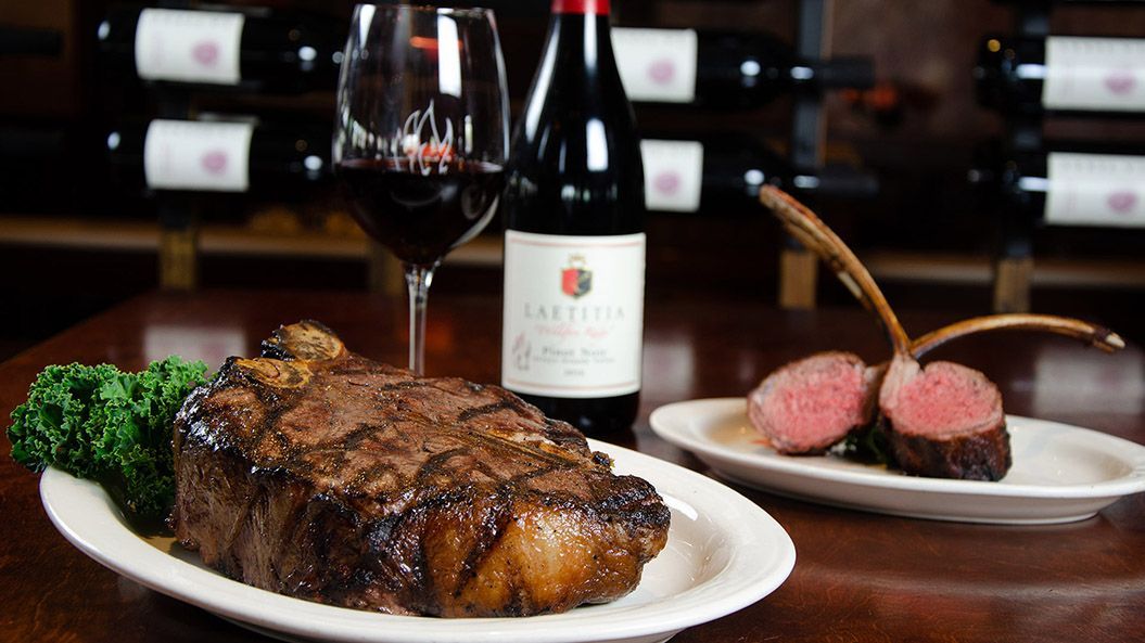 Steak and lamb chops with red wine in a restaurant setting.