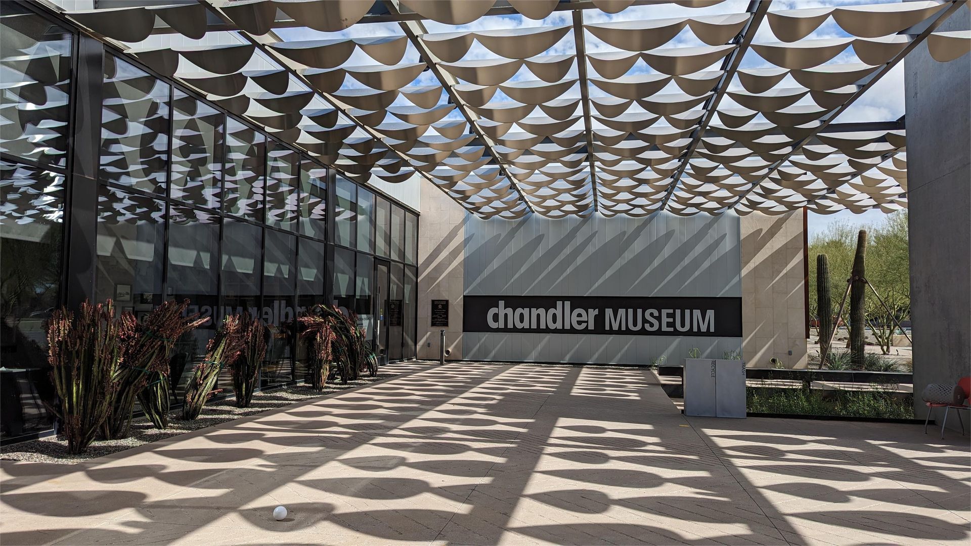 Entrance to the Chandler Museum, Arizona, with a shade structure casting shadows.