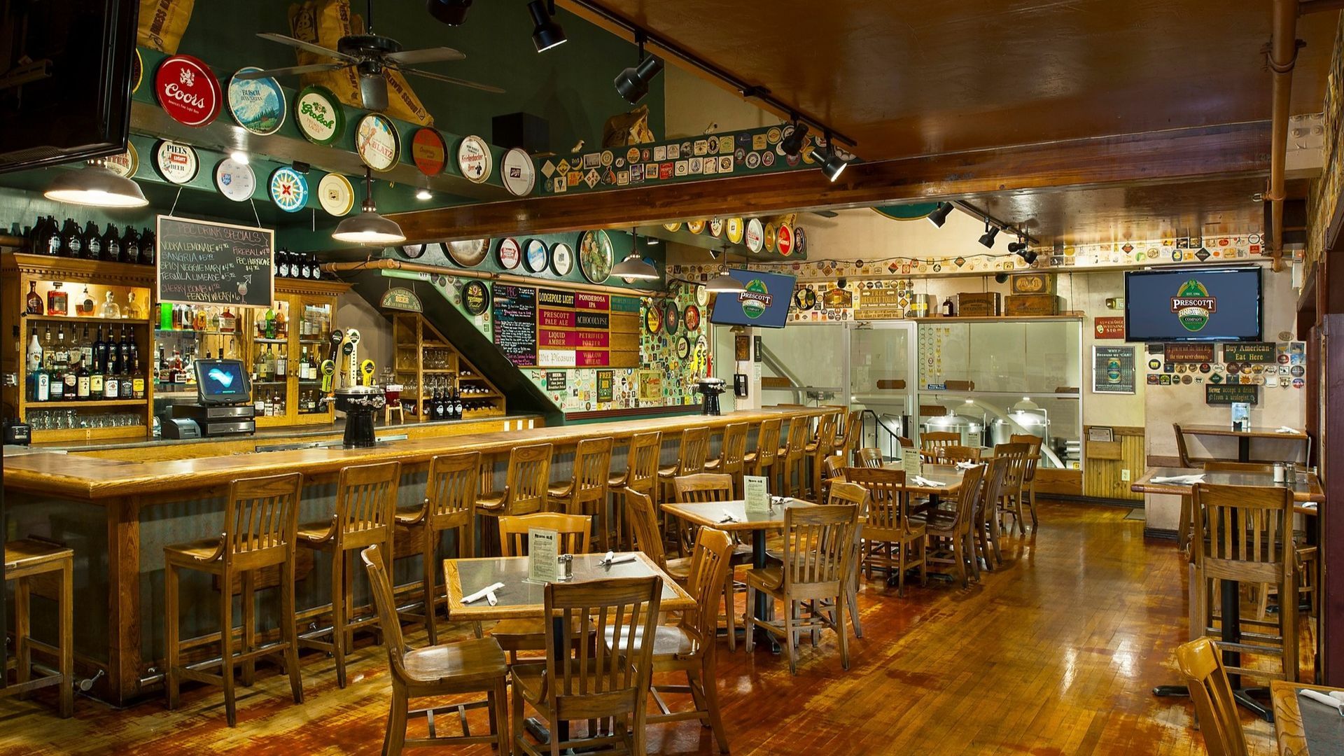 Interior view of a bar with a wooden bar, tables, and various decorations.