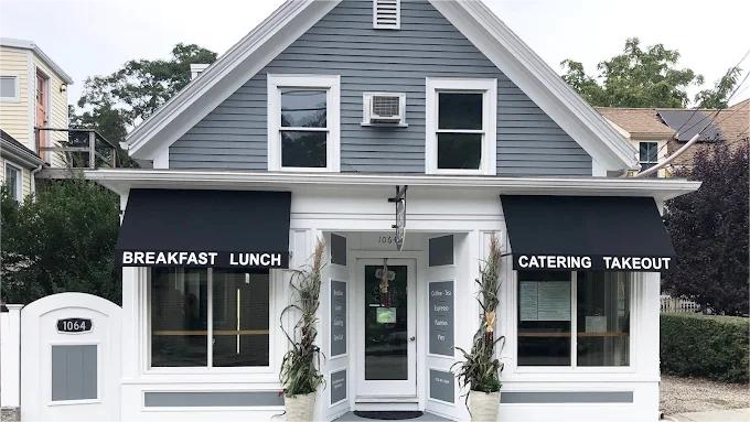 Gray house restaurant with black awnings: