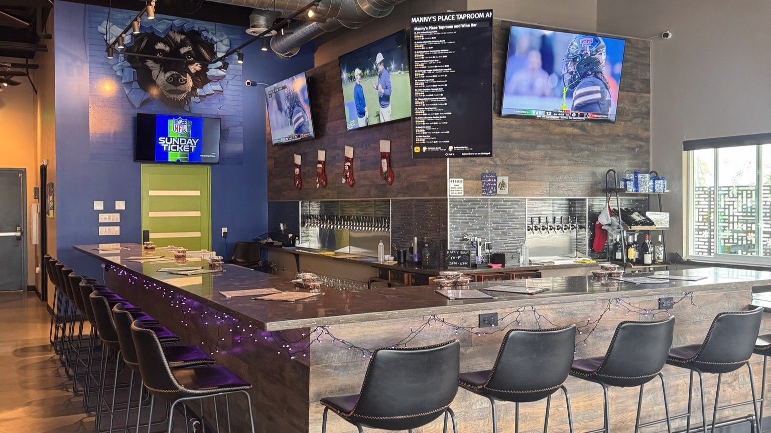 Bar interior with multiple TVs showing sports, barstools, and beer taps.