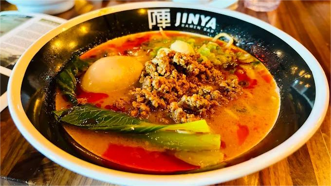 Bowl of ramen with noodles, vegetables, ground meat, and egg.