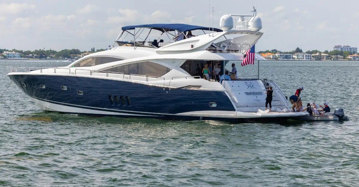 A large blue and white yacht on the water with people on board.