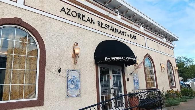 Azorean Restaurant & Bar exterior with arch windows, black awning, and blue tile artwork.