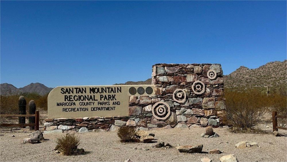 Sign for San Tan Mountain Regional Park, Arizona, with stone and metal accents, under a clear blue sky.