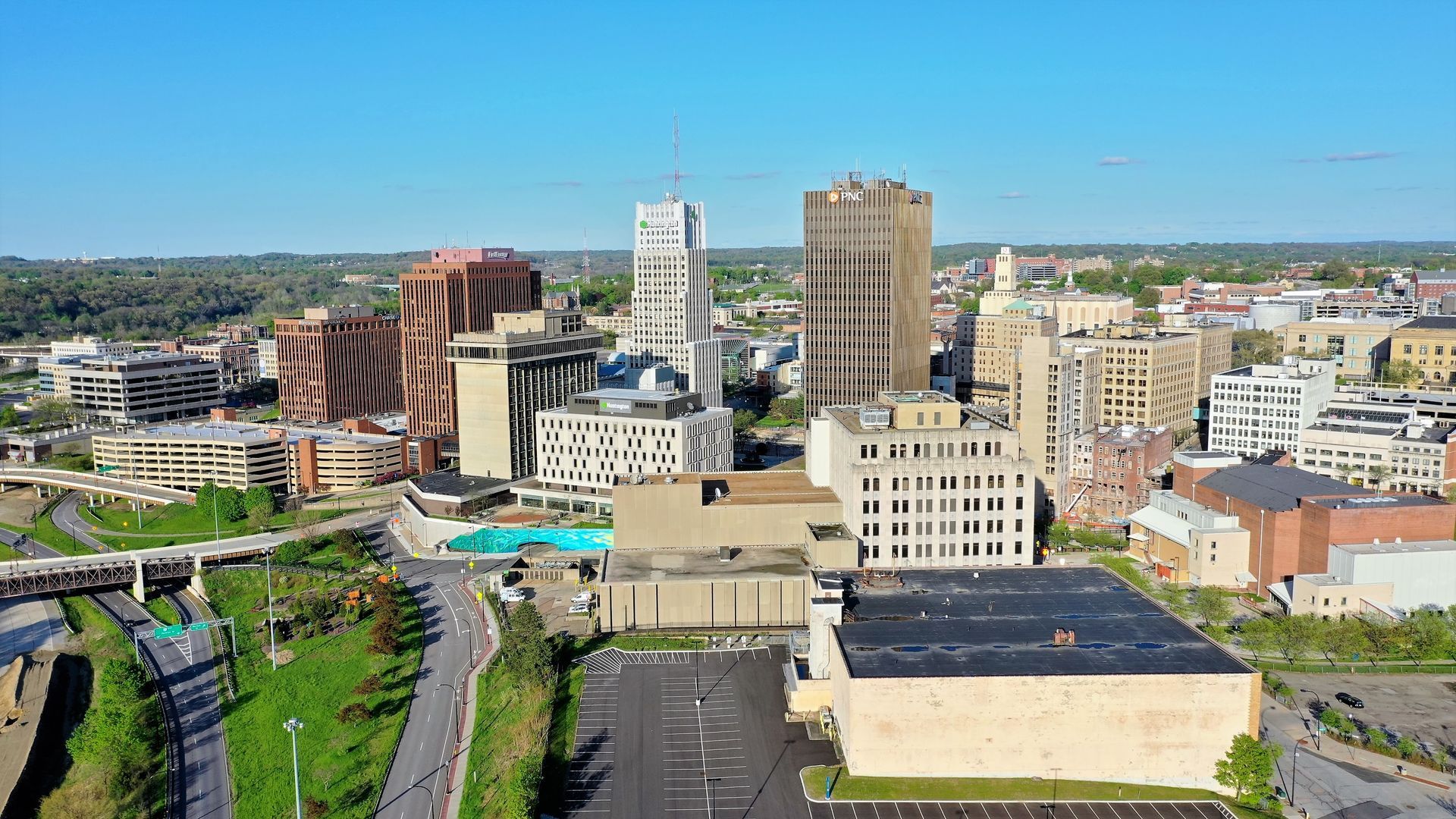 Downtown skyline with various buildings under a blue sky, including a unique brown architectural structure.