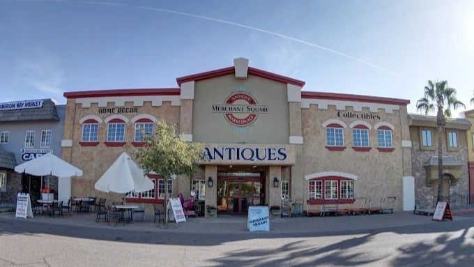 Antique store facade with cream-colored stucco, red trim, and a large