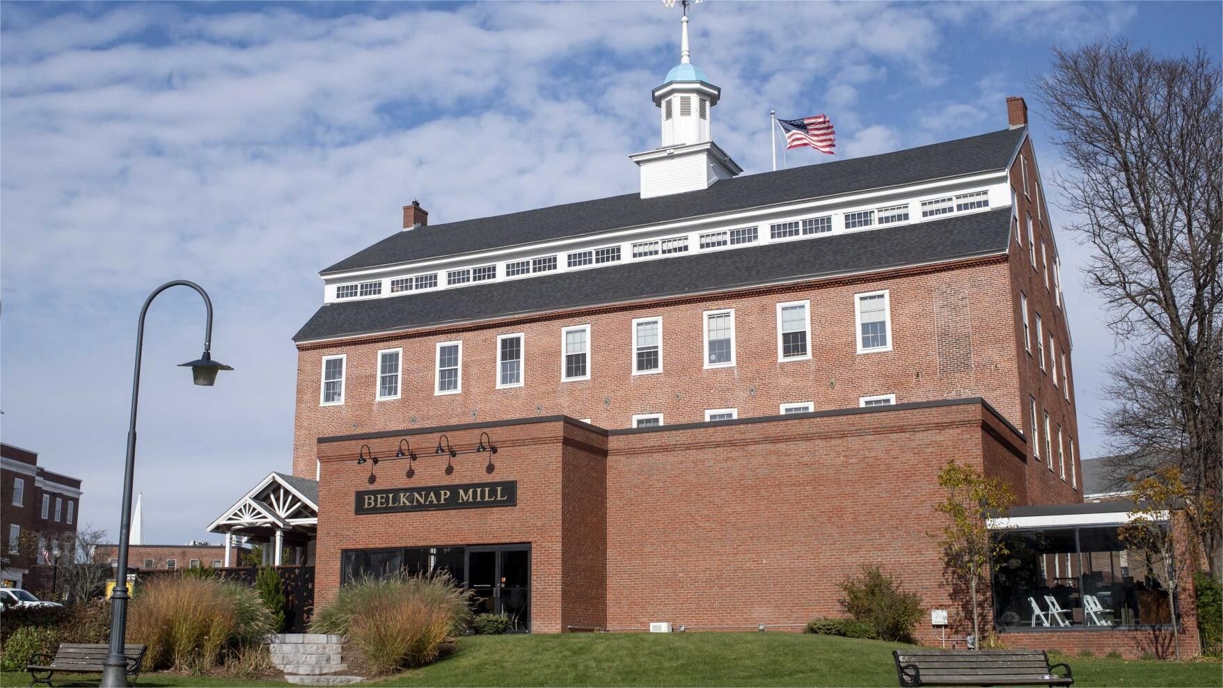 Brick building with a white cupola and American flag on top;