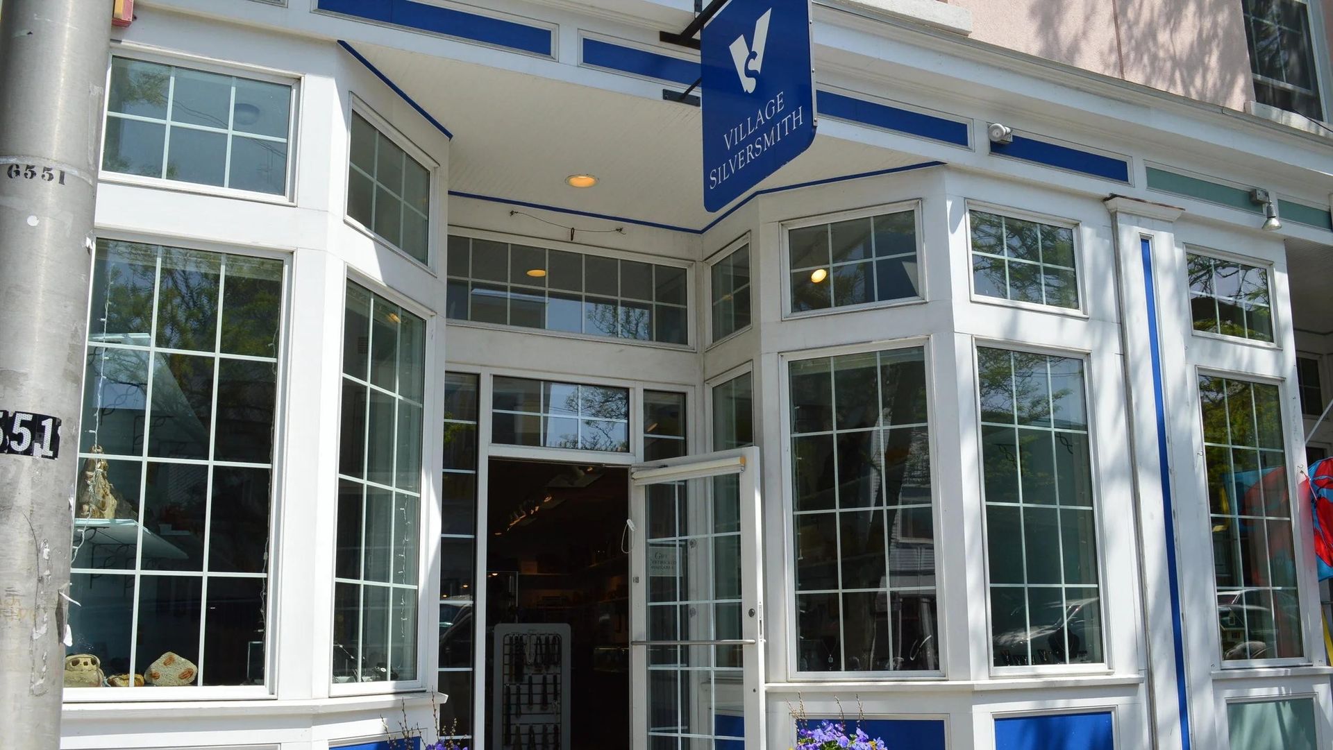 Storefront with white and blue trim, large windows, and open door.