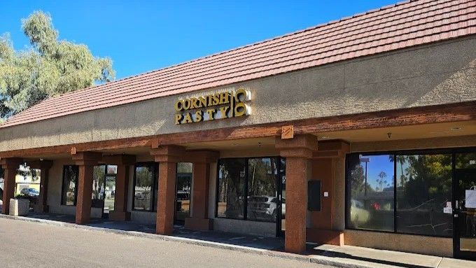 Exterior of Cornish Pasty Co. restaurant in a strip mall, with a red tile roof and tan facade.