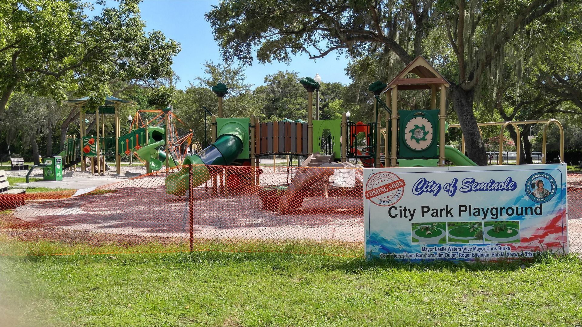Playground at City Park with slides, climbing structures, and a sign.