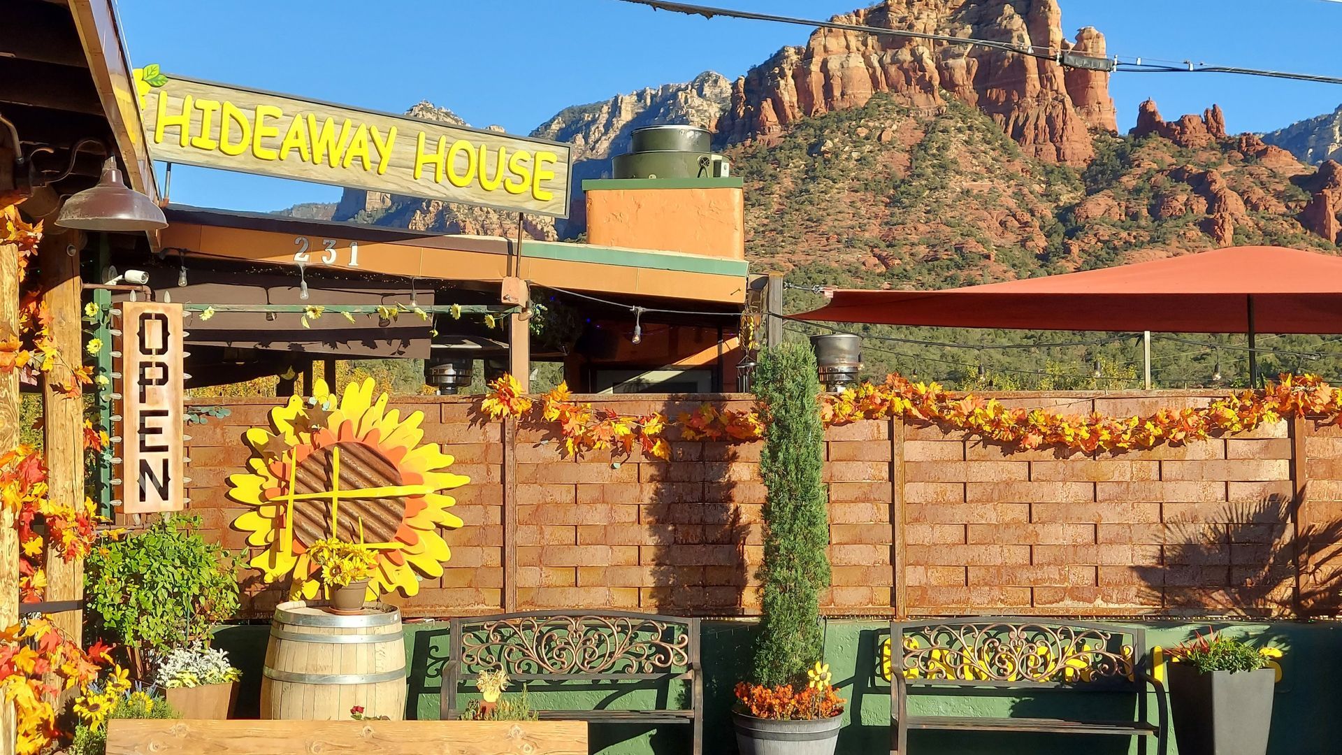 Hideaway House restaurant exterior with fall decor and red rock mountain backdrop.