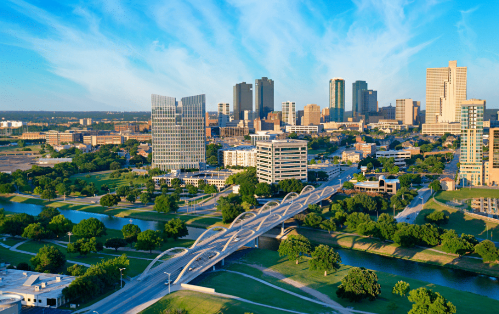 An aerial view of a city with a bridge in the foreground and a river in the background in Dallas-Fort Worth Metroplex, Texas