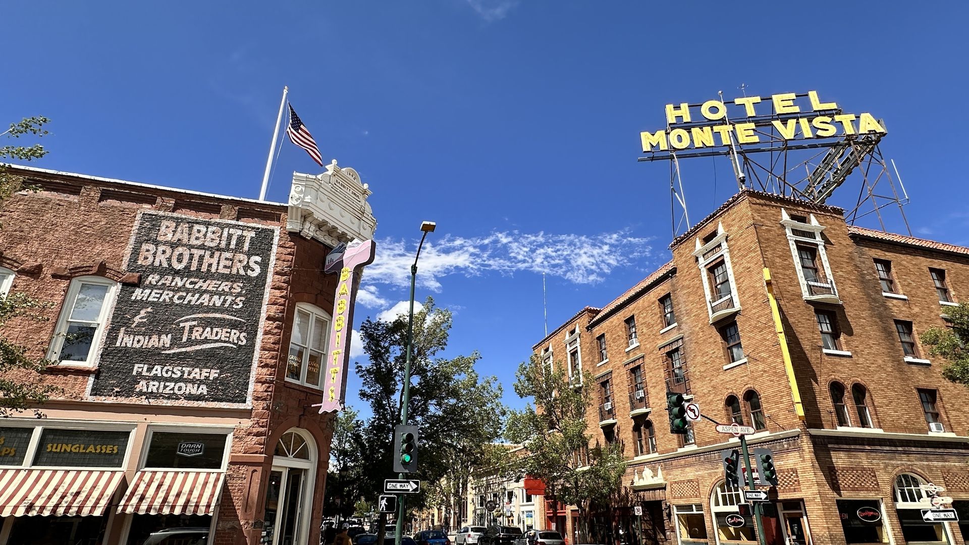A low-angle view of the historic brick Hotel Monte Vista and Babbitt Brothers building under a clear blue sky.