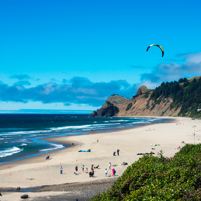 A kite is flying over a sandy beach in Lincoln City, Oregon