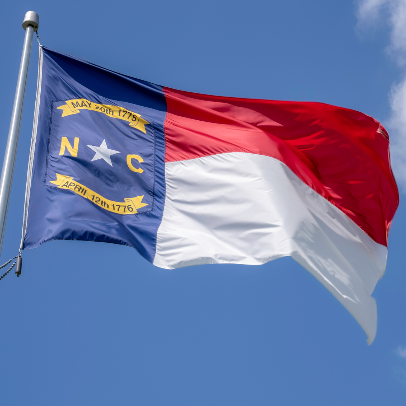 North Carolina State Flag over a property management building