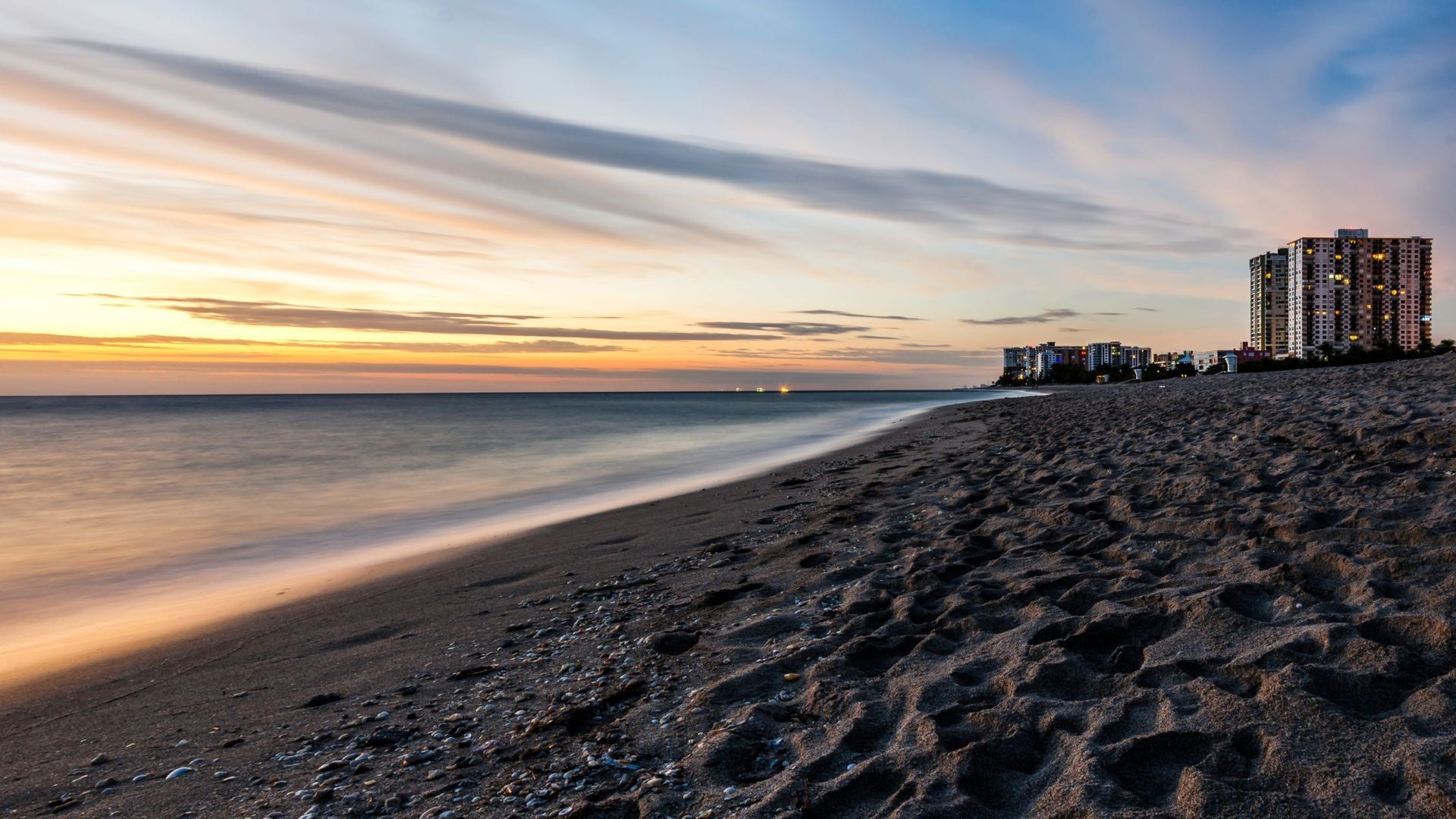 Pompano Beach with a building in the distance at sunset