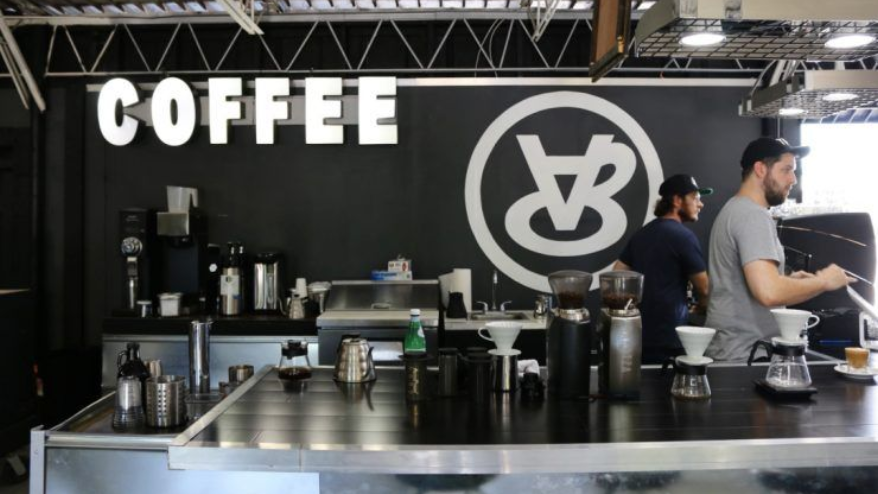 Coffee shop interior: barista preparing coffee, black counter,