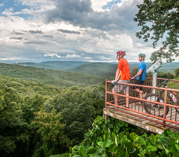 Beautiful views of Arkansas from a viewpoint, where 2 bikers take in the view